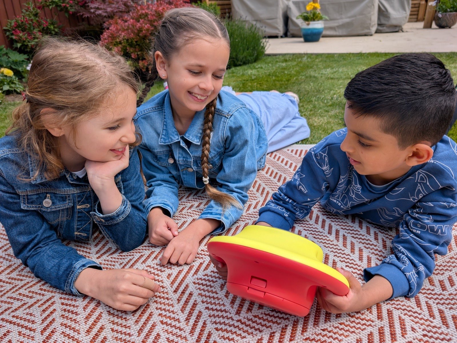 Three children playing with the Tale Spinner outdoors